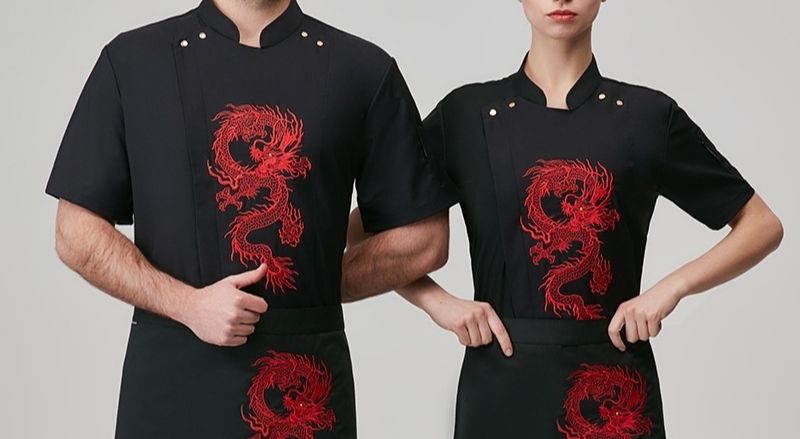 Hình thêu con rồng màu đỏ ngày giữa áo làm nổi bật phong cách của nhà hàng